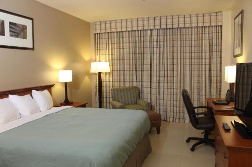a hotel room with a bed and a desk and a chair at Radisson Hotel Panama Canal in Panama City