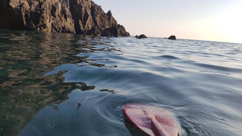 a kayak in the water next to a cliff at Villa Giordanelli in Scalea