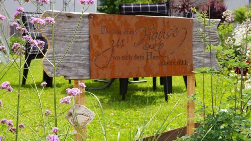 a sign in the middle of a garden with flowers at Haus Edeltraud in Mellau