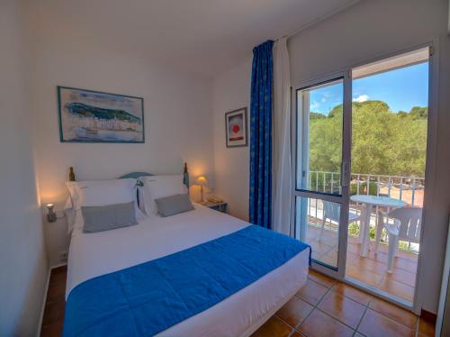 a bedroom with a bed and a large window at Hotel Calina in Cadaqués