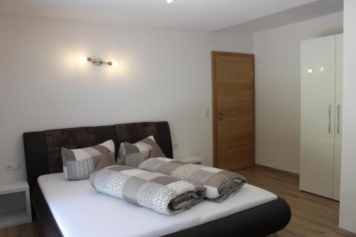 a bedroom with a bed with pillows on it at Apart Alpenjuwel in Sankt Leonhard im Pitztal