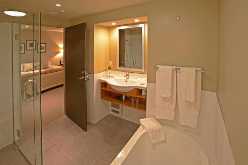 a bathroom with a tub and a sink and a shower at Distinction Fox Glacier - Te Weheka Boutique Hotel in Fox Glacier