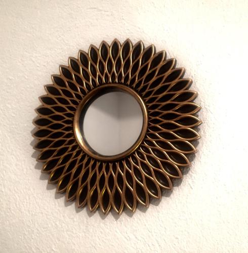 a mirror in the shape of a sunburst pattern on a wall at Residence Las Trojes Cdmx in Mexico City