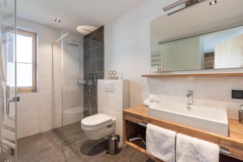 a bathroom with a sink and a toilet and a shower at Fetz Luxury Appartements in Steeg