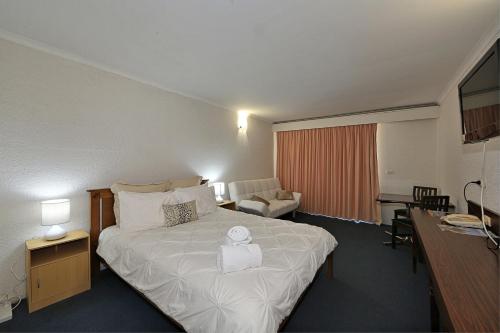 A bed or beds in a room at Alexandra Park Motor Inn
