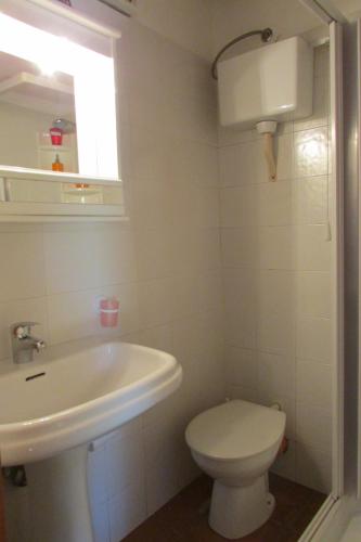 a white bathroom with a toilet and a sink at Agriturismo Capuano in Gangi