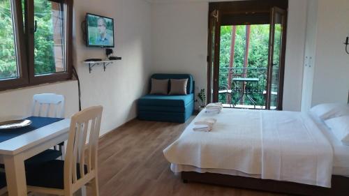 a bedroom with a bed and a desk and a table at Vasiliki in Virpazar