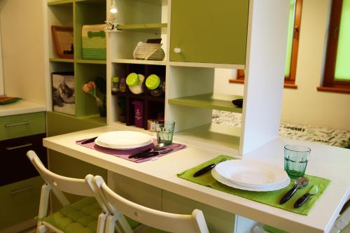 a kitchen with green cabinets and white plates on a counter at Green Bear in Sarajevo