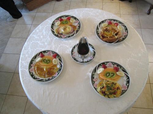 a white table with four plates of food on it at Oceanhillside B&B in Digby