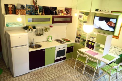 a kitchen with green cabinets and a white refrigerator at Green Bear in Sarajevo