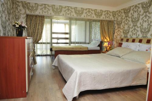 1 dormitorio con 2 camas y ventana en Orbi Residence Duplex Apartment en Batumi