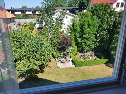 a view of a garden from a window at Mittes Rum in Alingsås