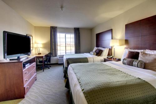 a hotel room with two beds and a flat screen tv at Cobblestone Hotel - Wayne in Wayne
