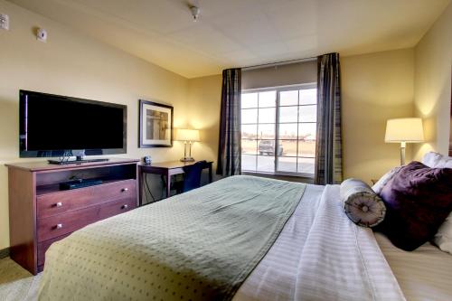 a bedroom with a large bed and a television at Cobblestone Hotel - Wayne in Wayne