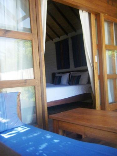 a bedroom with two bunk beds and a wooden table at Indigo Bungalows in Gili Trawangan