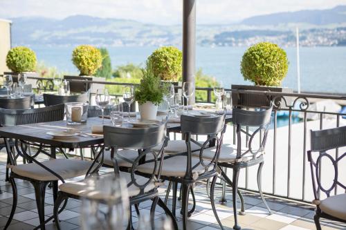 einen Tisch und Stühle auf dem Balkon eines Restaurants in der Unterkunft Hotel Hirschen am See in Meilen