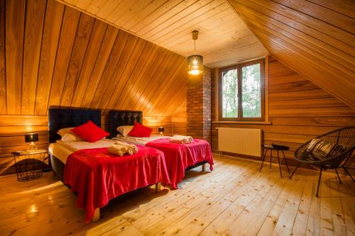 a bedroom with two beds in a wooden house at Dwa Pomosty in Augustów
