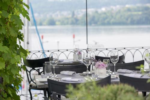 a table with wine glasses and napkins on it at Hotel Hirschen am See in Meilen