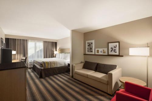 una camera d'albergo con letto e divano di Country Inn & Suites by Radisson, Sandusky South, OH a Milan