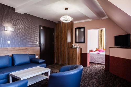1 dormitorio y sala de estar con muebles de color azul. en Rezydencja Zapiecek, en Świeradów-Zdrój