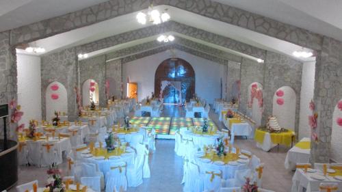 a large banquet hall with white tables and chairs at Hotel Villa Monarca Inn in Zitácuaro