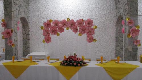 a table with yellow and pink flowers on it at Hotel Villa Monarca Inn in Zitácuaro