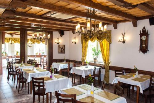 a restaurant with white tables and chairs and a clock at Rezydencja Zapiecek in Świeradów-Zdrój