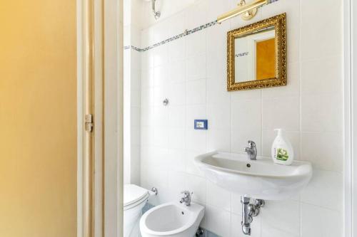a bathroom with a sink and a toilet and a mirror at La Casetta di Manu' a San Pietro in Rome