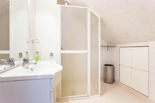 Un baño blanco con lavabo y ducha en Fjord View Apartments, en Stavanger