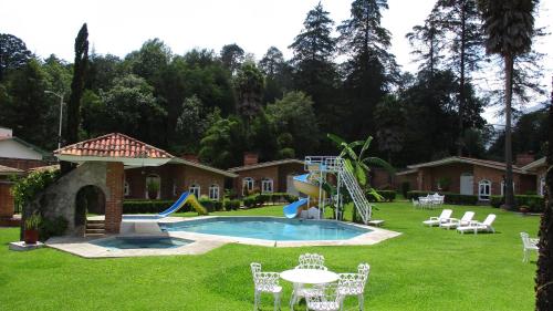 a pool with a slide in a yard at Hotel Villa Monarca Inn in Zitácuaro
