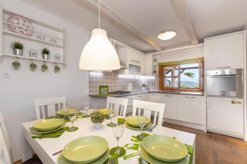 a kitchen and dining room with a table and chairs at Kuslec Holiday Home in Desinić