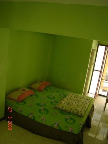 Dormitorio verde con cama con pared verde en Kaset Guesthouse, en Bangkok