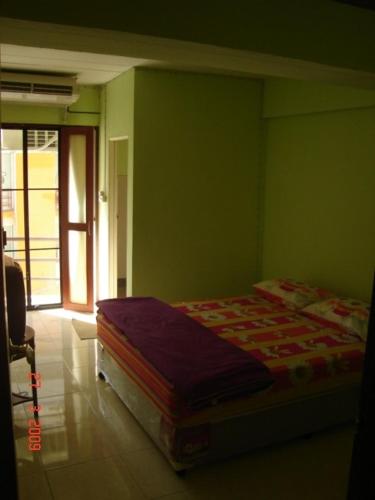 1 dormitorio con 1 cama en una pared verde en Kaset Guesthouse, en Bangkok