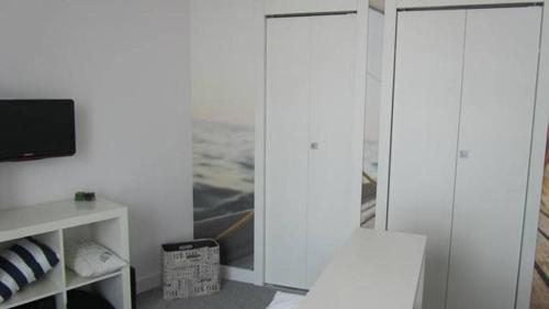 a living room with a tv and a white wall at Sea Towers Gdynia in Gdynia