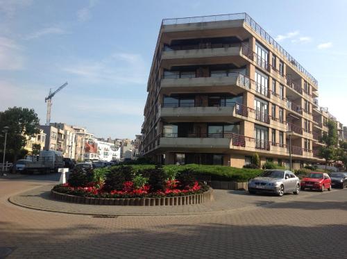 un gran edificio con un lecho de flores delante de él en La Bohème Koksijde, en Koksijde