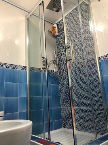 a bathroom with a shower with blue tiles at Holiday House Ruocco in Maiori