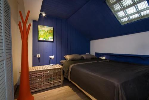a blue bedroom with a bed and a window at Cozy Apartment in the Carmel Center in Haifa