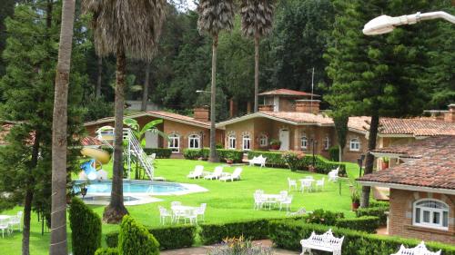 a house with a large yard with a swimming pool at Hotel Villa Monarca Inn in Zitácuaro