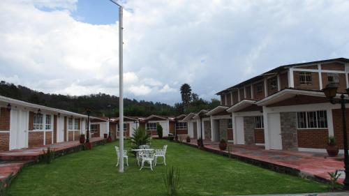 a row of houses with a table and chairs in the yard at Hotel Villa Monarca Inn in Zitácuaro