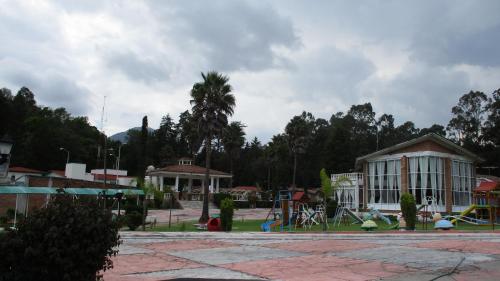 a playground in a park with a building and a playground at Hotel Villa Monarca Inn in Zitácuaro
