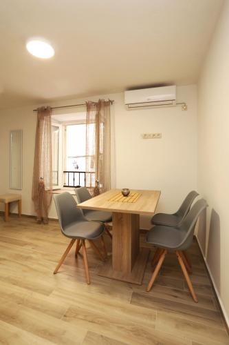 a dining room with a wooden table and chairs at Nona Zena in Korčula