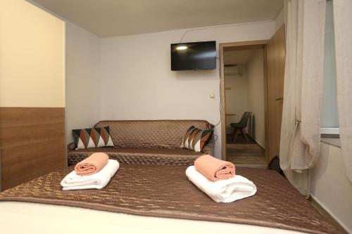 Un dormitorio con dos camas con toallas con caras en ellas. en Nona Zena, en Korčula