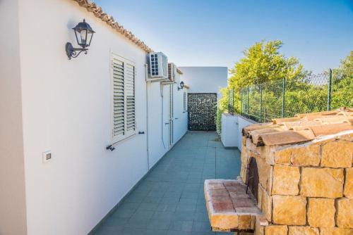 a walkway leading to a white building with a stone wall at B&B Le Balate in Augusta