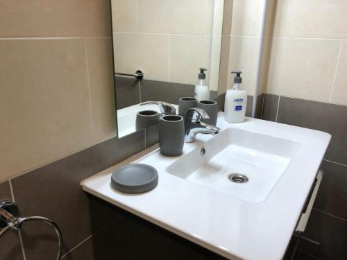 uma casa de banho com um lavatório branco e um espelho. em Vivienda Sara em Valle Gran Rey