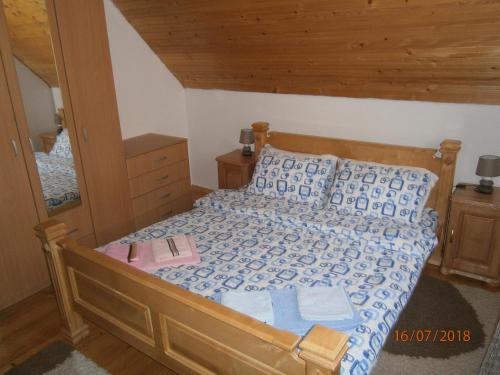 a bedroom with a bed with a wooden head board at Wolf Apartment in Žabljak