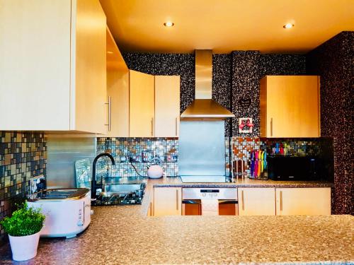 a kitchen with white cabinets and a sink at Glasgow Central Station SKYLINE Apartment with Parking (2 bedrooms, 2 bathrooms, 1 living room-Kitchen) in Glasgow