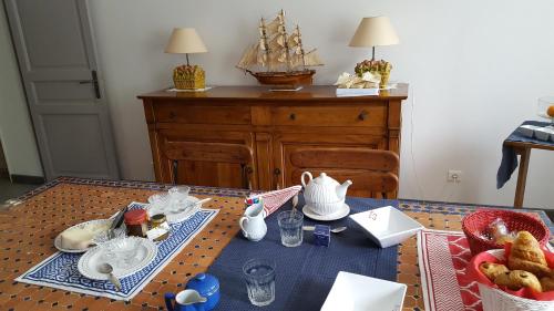 a table with a tea set with a ship on it at Maison Lalanne in Castelnau-Chalosse