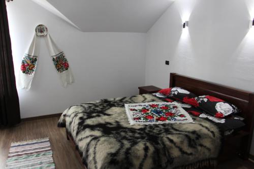 a bedroom with a bed with a blanket and pillows at Popasul Călătorului in Moisei