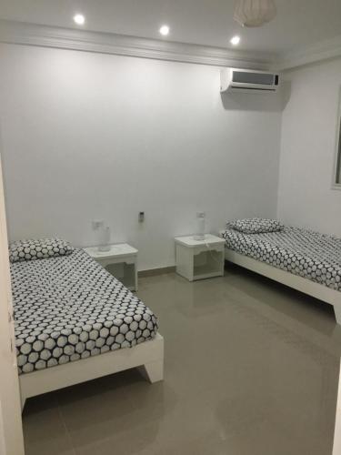 a white room with two beds and a sink at Belle Villa Avec Piscine sans vis a vis in Midoun