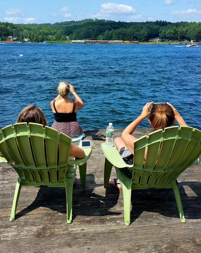 two women sitting in chairs looking at the water at Birch Knoll Motel in Laconia